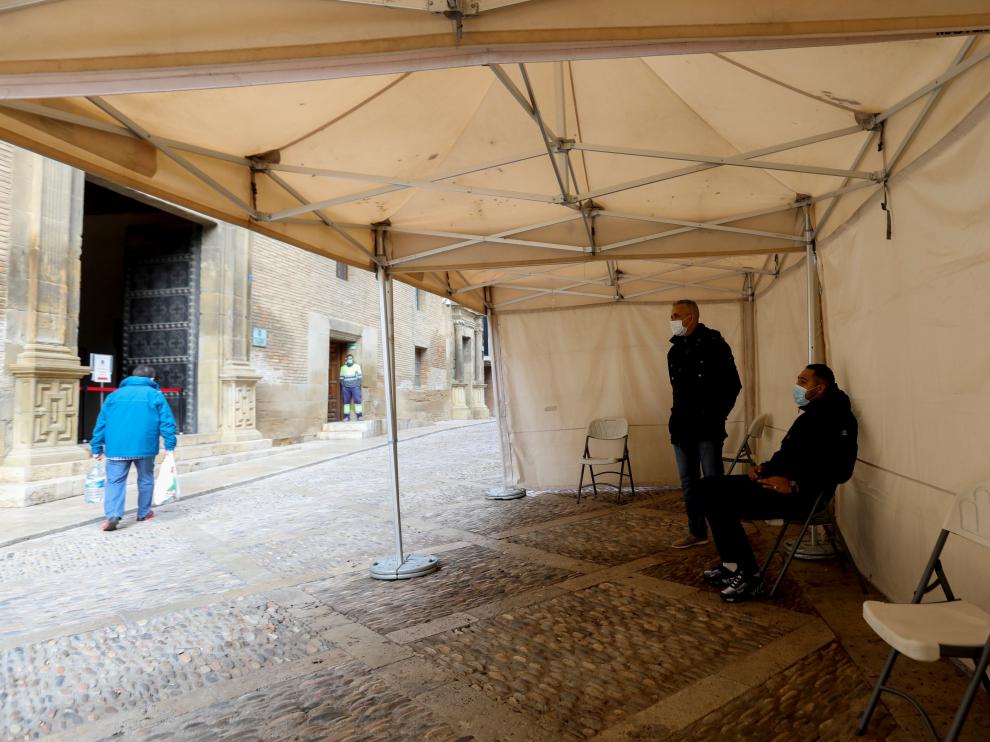 Dos personas aguardan bajo la carpa su turno en las oficinas municipales.