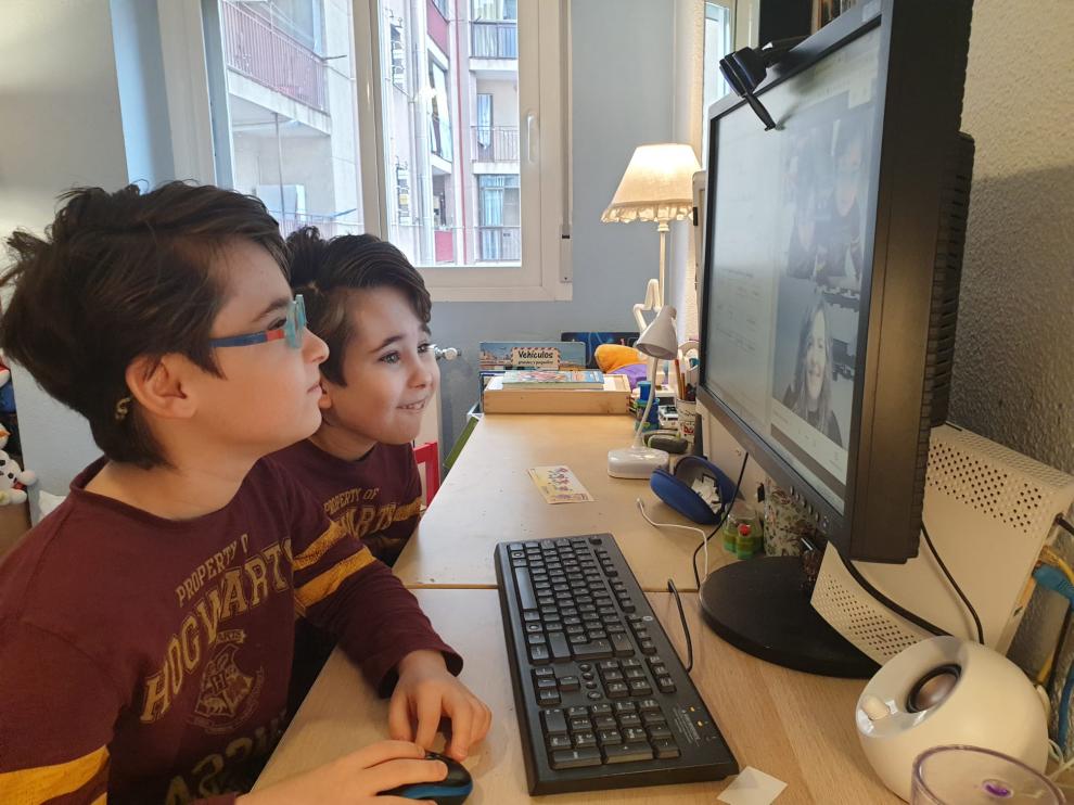 Guillermo, en primer plano con gafas, y Nicolás comectados a la clase con Adriana.