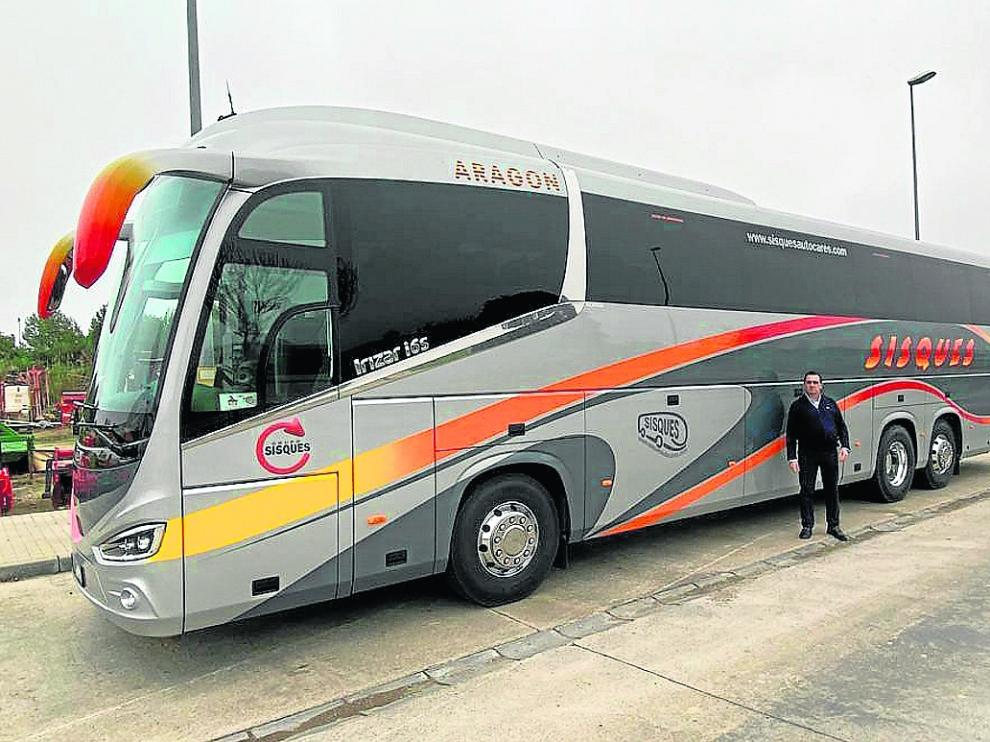 Guillermo Sisqués, junto a uno de los 14 autobuses de la flota de su empresa, con base en Binéfar.