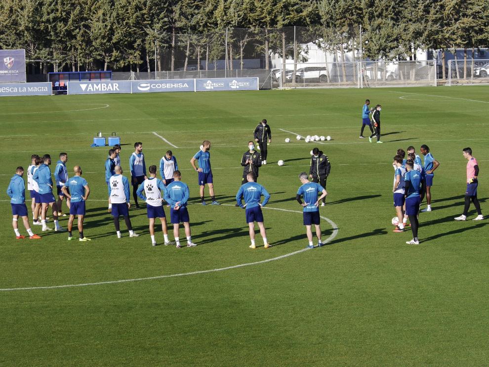 Los jugadores de la SD Huesca reciben instrucciones en el entrenamiento de este lunes.
