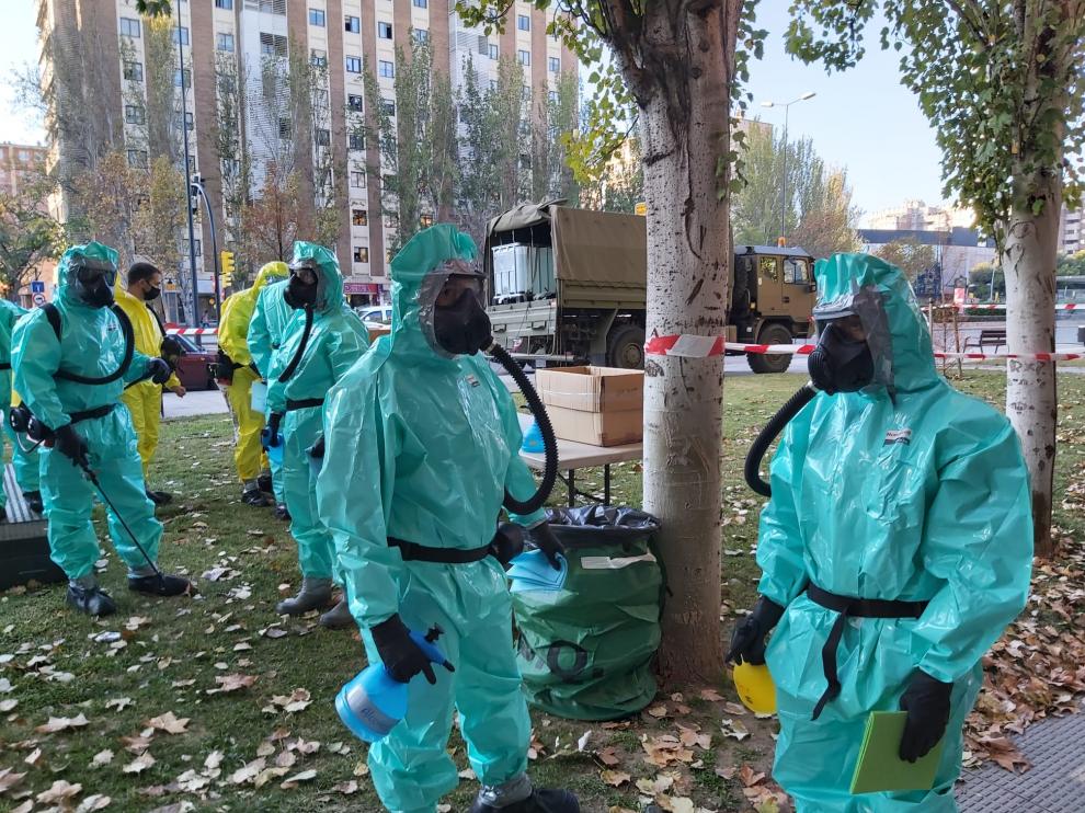 Militares ataviados con la equipación especial anticovid para desinfectar la residencia de la APAC en el Actur de Zaragoza, este lunes.