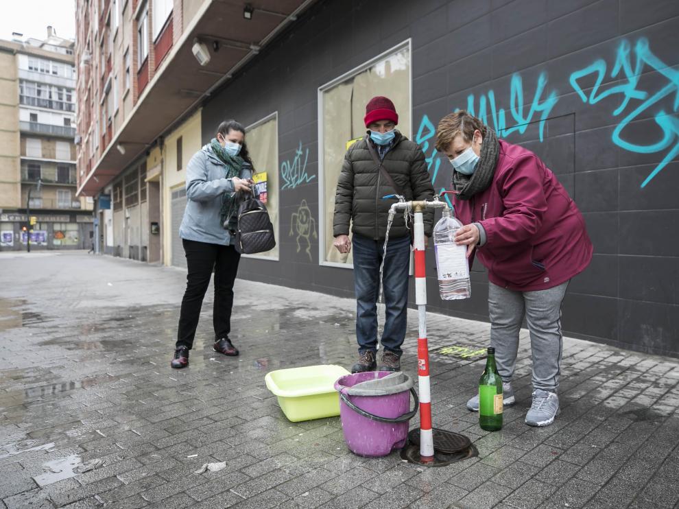Esmeralda Antas, vecina de la plaza Utrillas, llena una garrafa en el grifo habilitado en la calle.