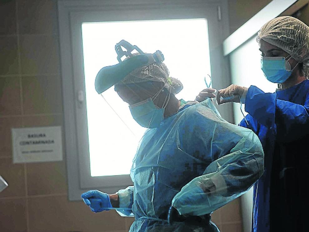 Las médicos de la unidad de hospitalización del centro covid de Casetas, María Jesús Esquillor y Rebeca Marinas, se ponen los equipos de protección individual