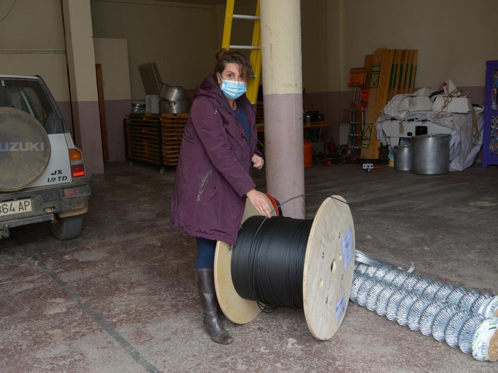 Una empleada municipal de Loscos muestras las bobinas de fibra usadas para cablear el pueblo.