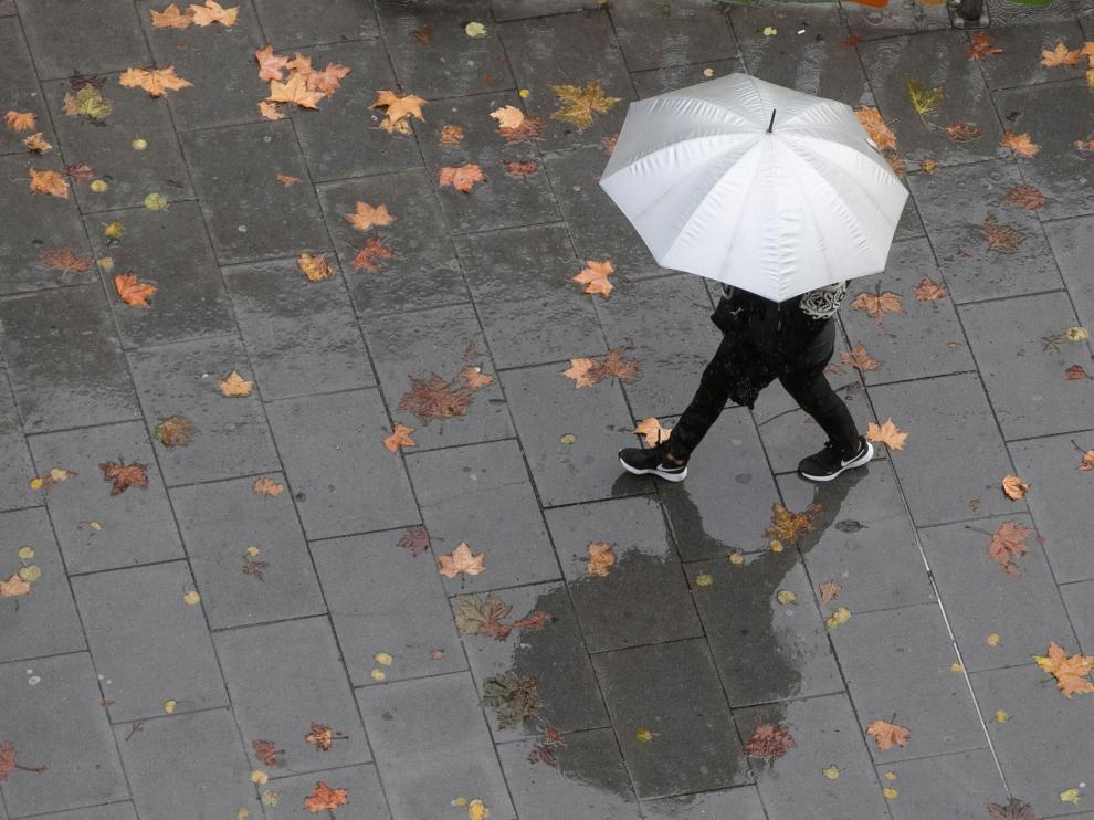 Una persona camina bajo la lluvia en una imagen de archivo. Aemet en Aragón prevé para los próximos días una sucesión de frentes, con precipitaciones.