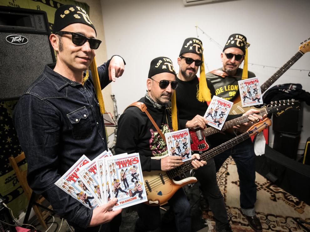 Los integrantes de Los Twangs posan con su cómic en su local de ensayo en Zaragoza.