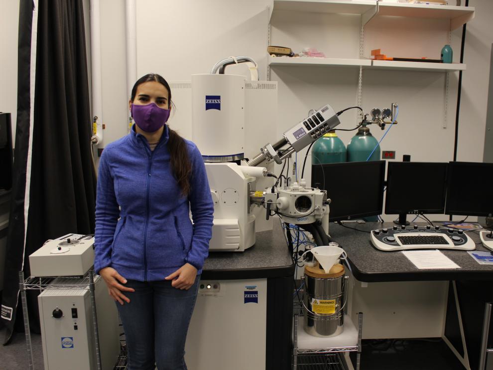 Irene Andreu, junto a un microscopio electrónico del Consorcio de Nanociencia y Nanotecnología de la Universidad de Rhode Island.