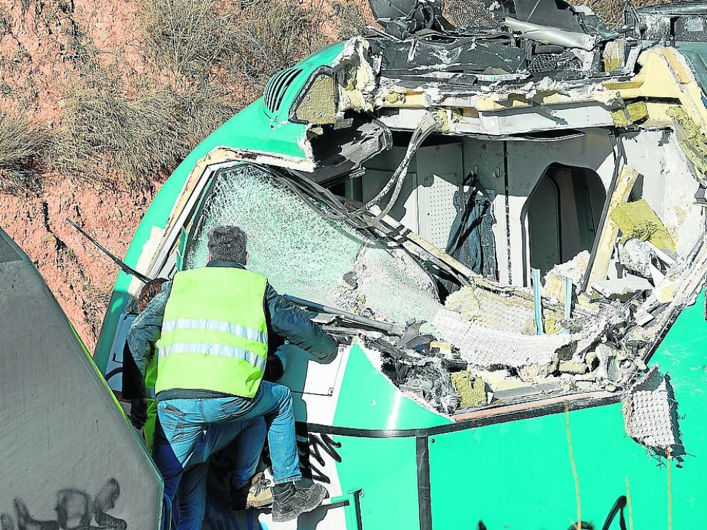 Un operario examina la cabina del tren de mercancías atrapado en el túnel, aplastada por los cascotes.
