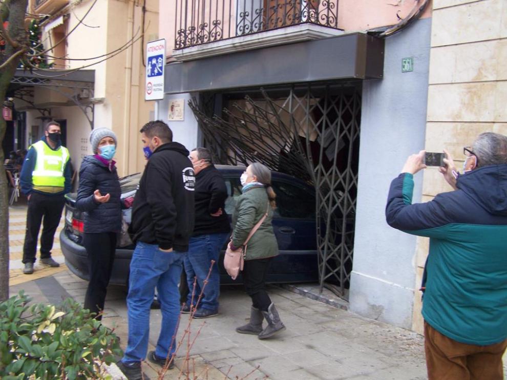 El coche se ha llevado por delante la valla metálica que defendía el escaparate del establecimiento y se ha metido dentro del local, en una calle de Graus.