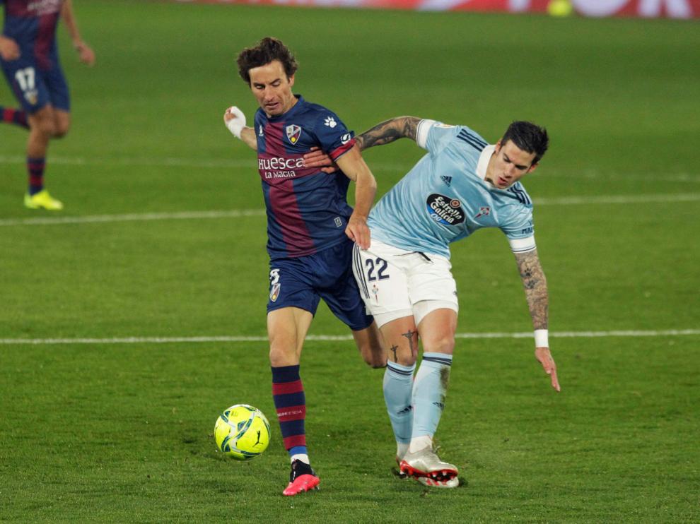 El jugador del Celta de Vigo Santi Mina , pugna por un balón, con el jugador del Huesca Mosquera