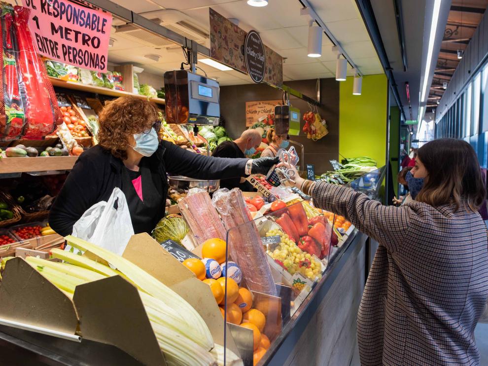 Una consumidora adquiere fruta en un puesto del Mercado Central de la capital aragonesa.