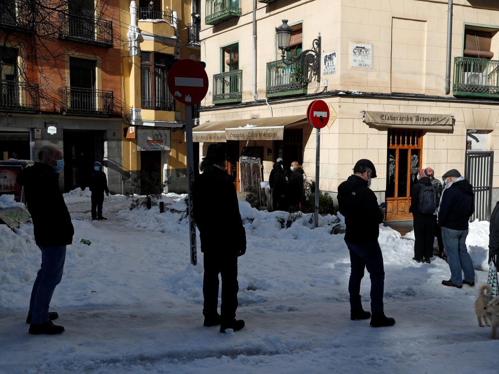 Filas para entrar a un establecimiento en Madrid por el temporal.