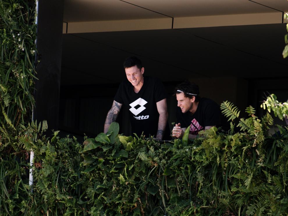 Algunos tenistas, asomados al balcón de uno de los hoteles donde están confinados en Australia.