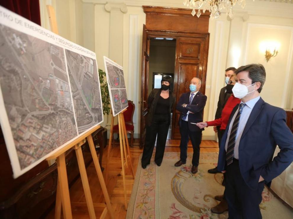 El alcalde de Huesca, en primer término, contempla los paneles donde se define la superficie y la ubicación del suelo cedido para el centro de emergencias y seguridad ciudadana.
