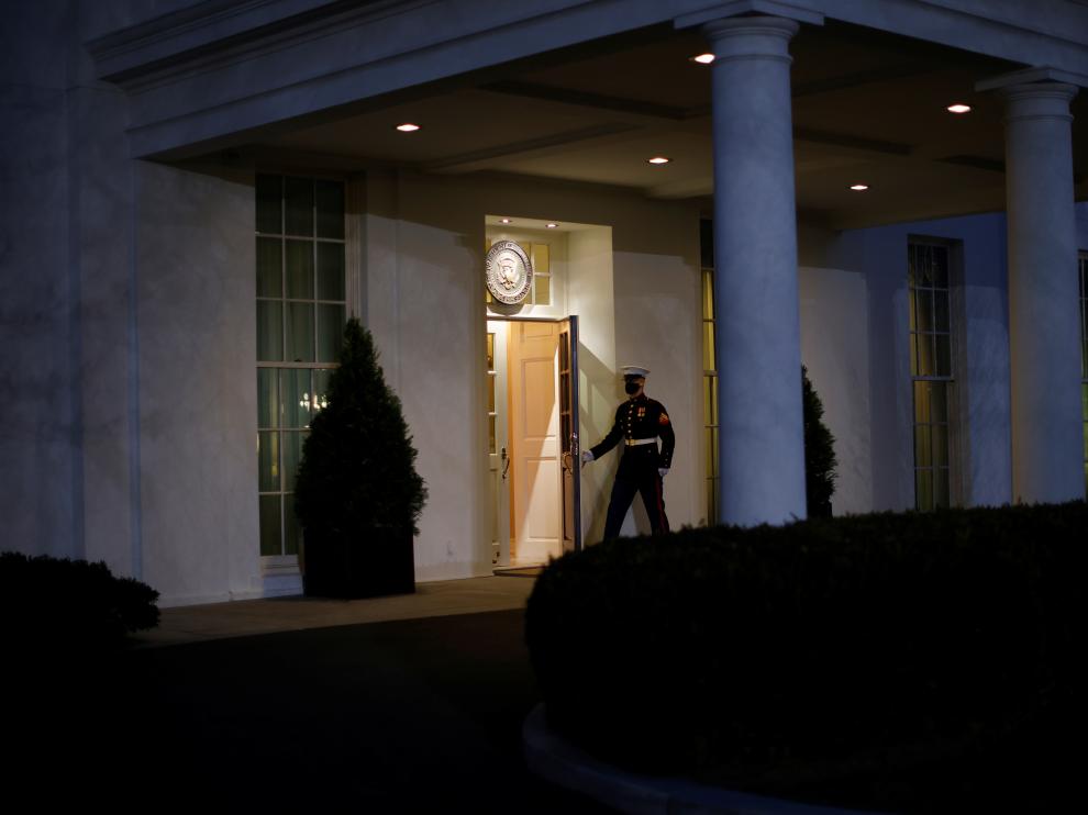 A U.S. Marine opens a door of the West Wing door, an indication that U.S. President Donald Trump is in the Oval Office during his last day in office, in Washington U.S.