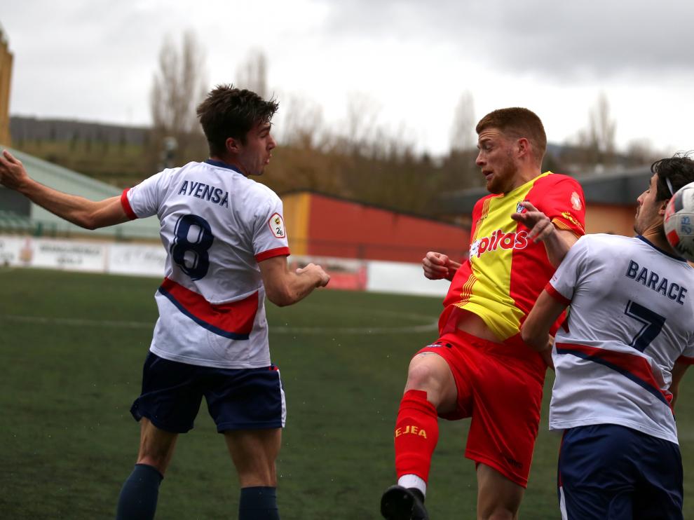 Carlos Vicente lucha con dos rivales por un balón aéreo.