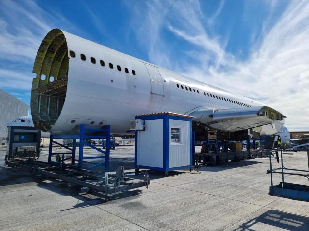 Fuselaje de un avión a medio desmantelar en la planta de reciclado de Tarmac en el aeropuerto.