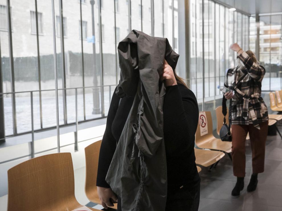 Dos de las acusadas se cubren el rostro al entrar a la sala de vistas de la Audiencia de Zaragoza.
