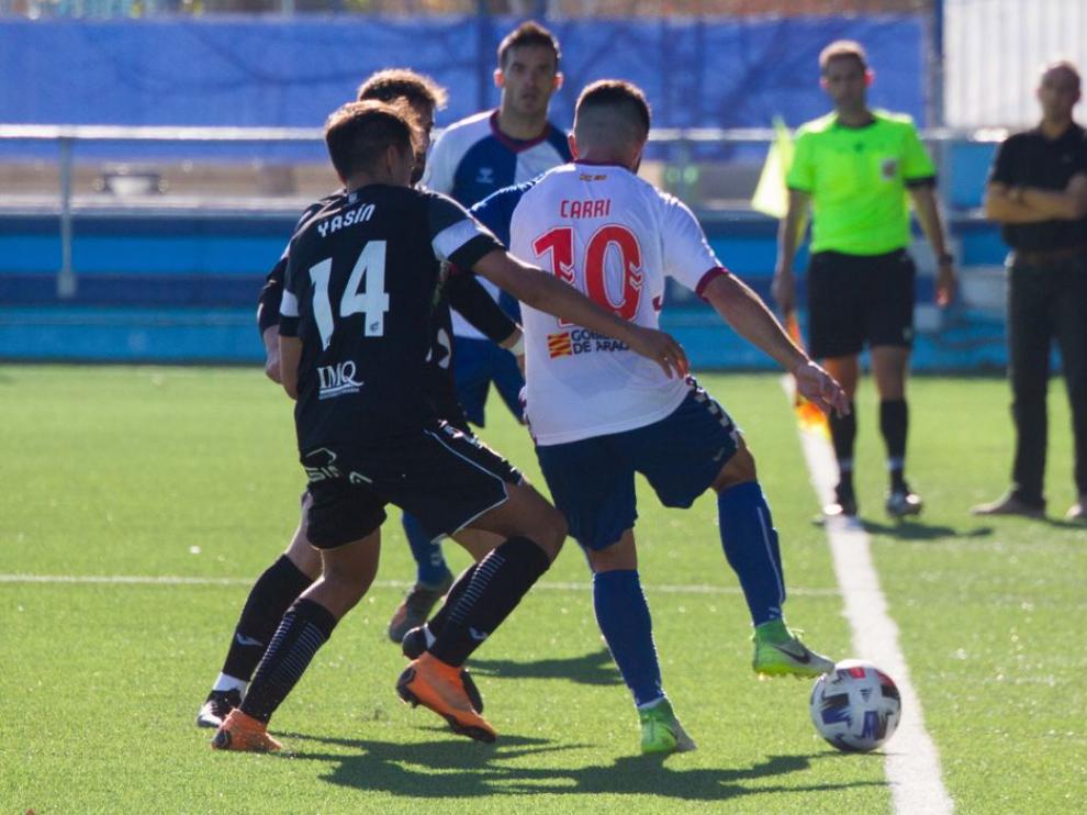 Carri protege el balón ante la presión de un jugador rival.