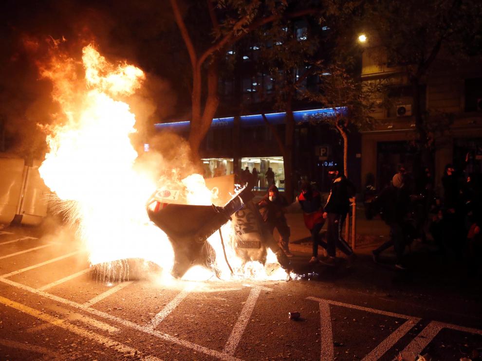 Varias personas queman contenedores en una manifestación contra la encarcelación de Hasel, en Barcelona.