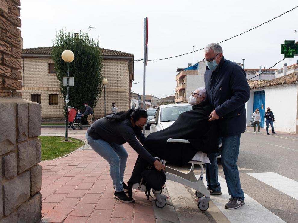 Carlos Casamián (hijo de Ángeles) y Margoth Cano (su cuidadora) levantan la silla a las puertas del centro de salud.