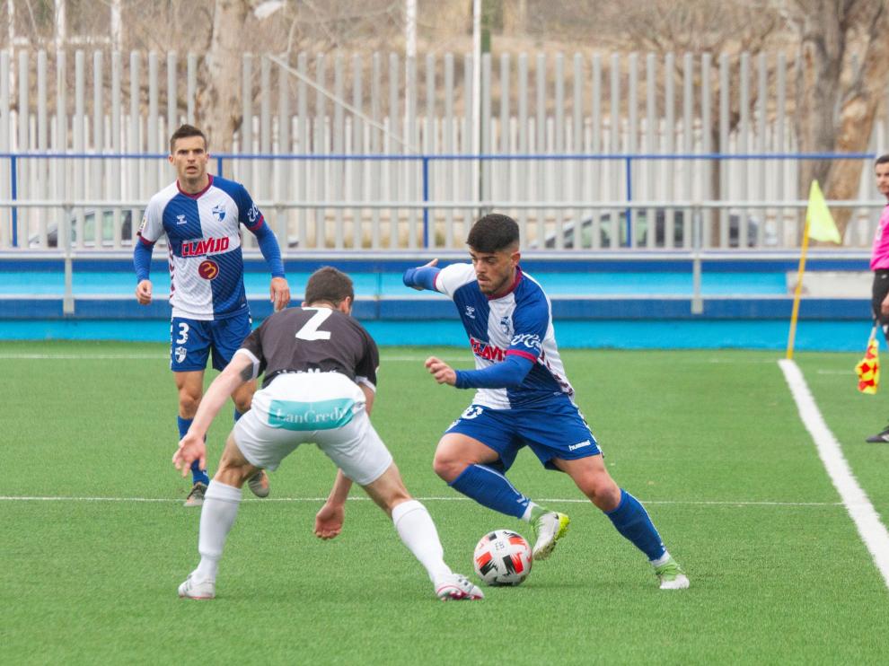 Carri conduce el balón ante la presión de un jugador rival.
