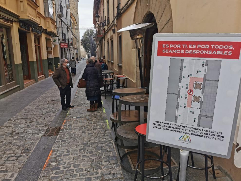 Terrazas vacías en Jaca, que cuida la prevención con estos carteles para separar el tránsito en las calles.