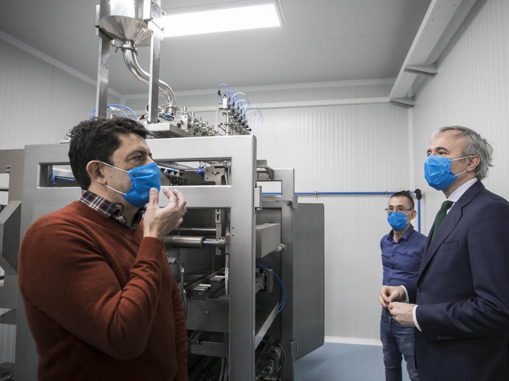 Antonio Domínguez, director técnico de Making Mask, explica al alcalde de Zaragoza Jorge Azcón el funcionamiento de la nueva máquina que producirá monodosis de gel hidroalcohólico.