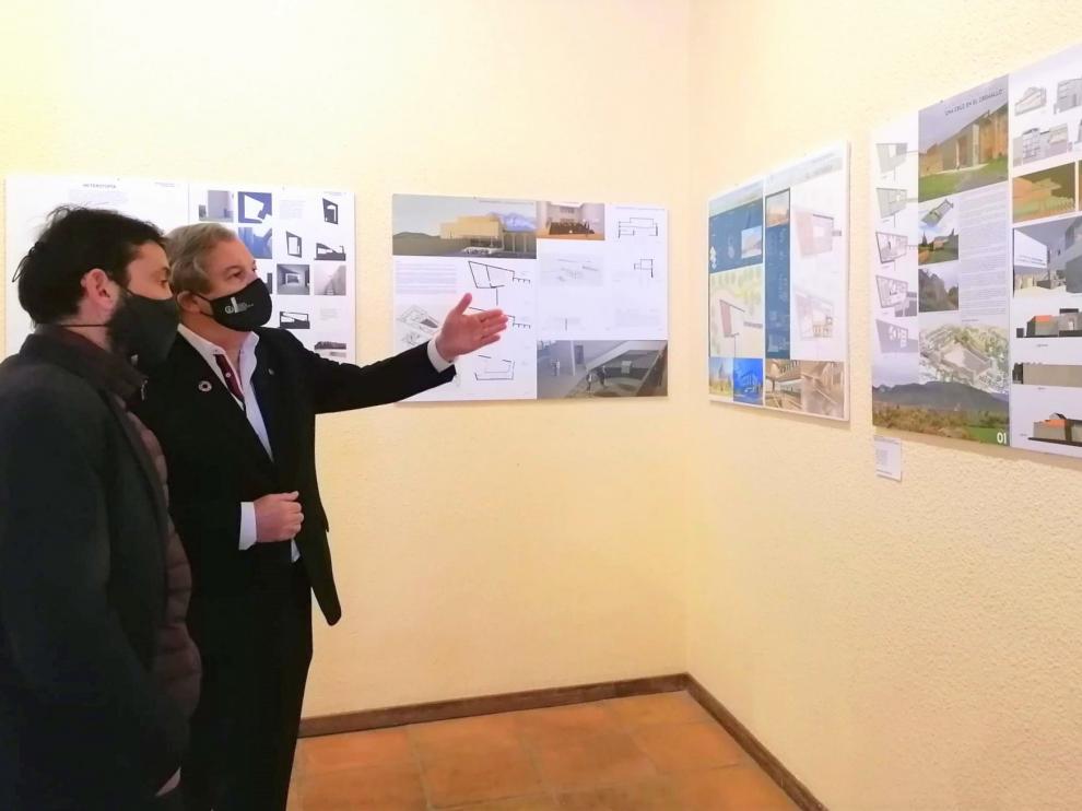 El alcalde de Aínsa, Enrique Pueyo, y el decano del Colegio de Arquitectos, Pedro J. Navarro observan los proyectos expuestos.