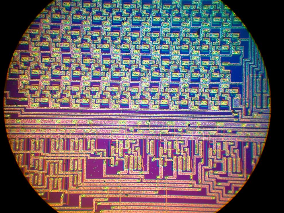 Microchip visto al microscopio; pueden apreciarse componentes basados en semiconductores y pistas metálicas.