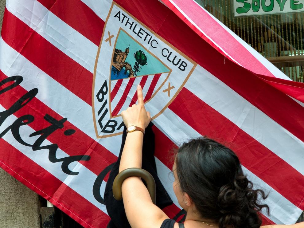 Una mujer señala una bandera del Athletic de Bilbao