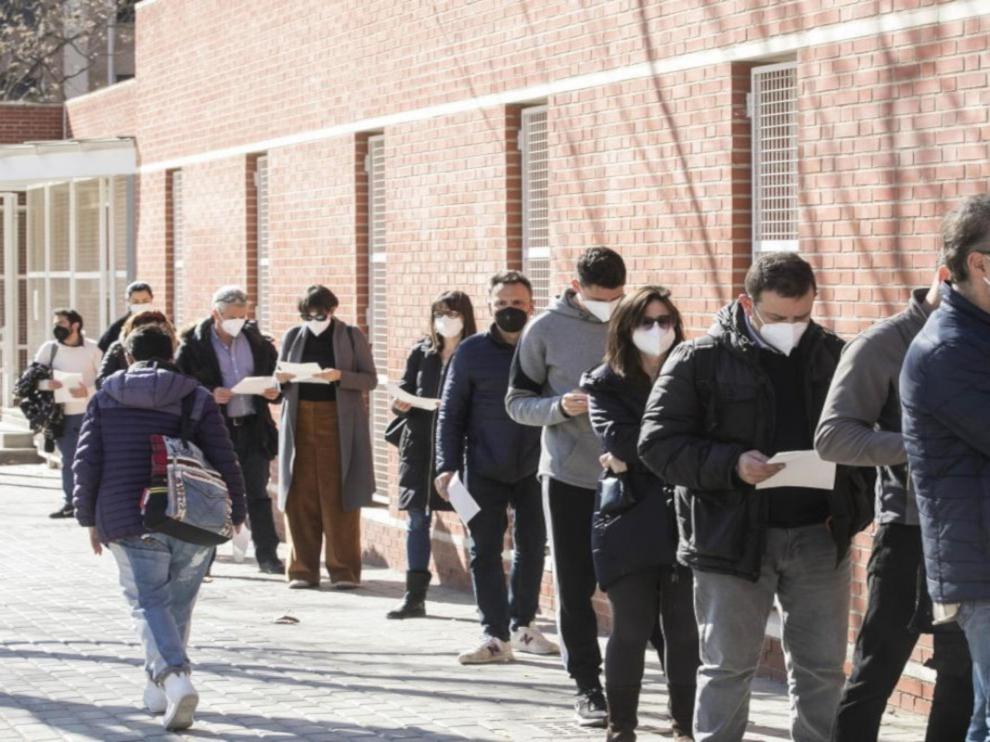 Fila de personas a la espera de ser llamados para vacunarse en el barrio de la Bombarda (Zaragoza).