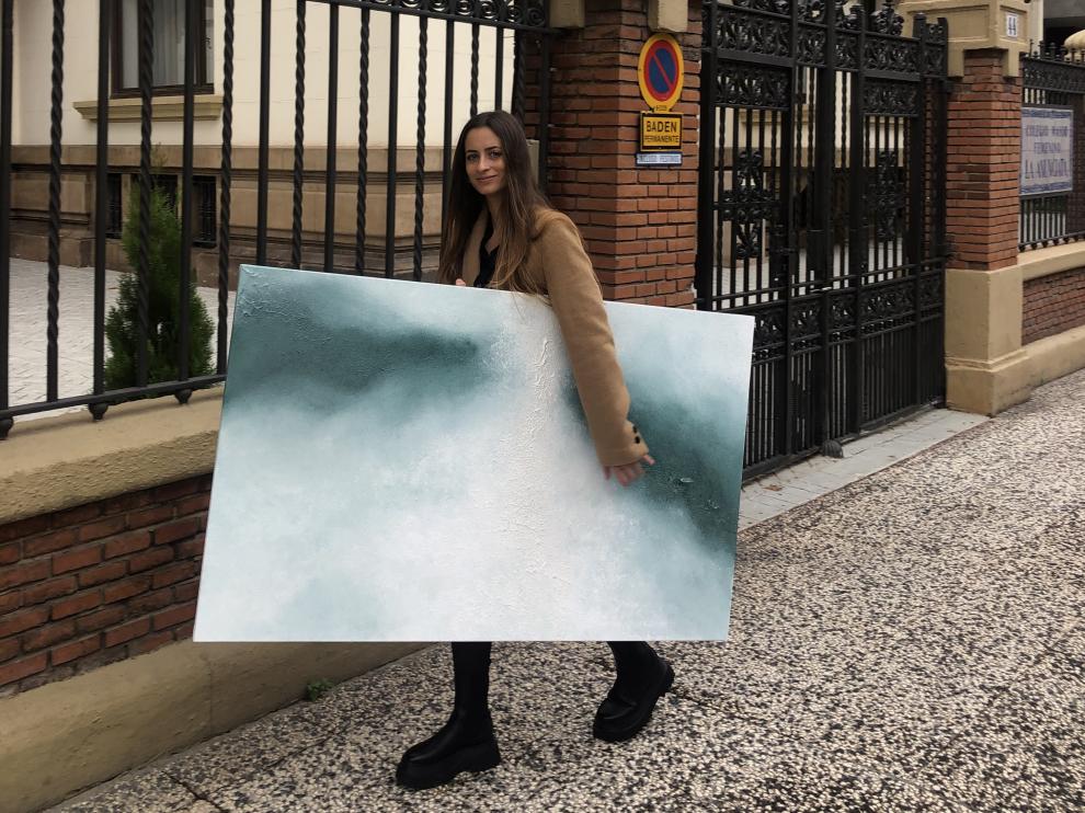 La joven zaragozana Carmen Dolofan, cargando una de sus obras.