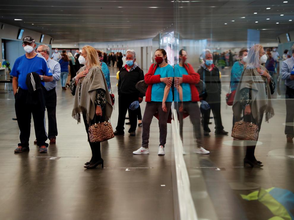 People wait in line to receive AstraZeneca's COVID-19 vaccine at a vaccination centre, in Madrid