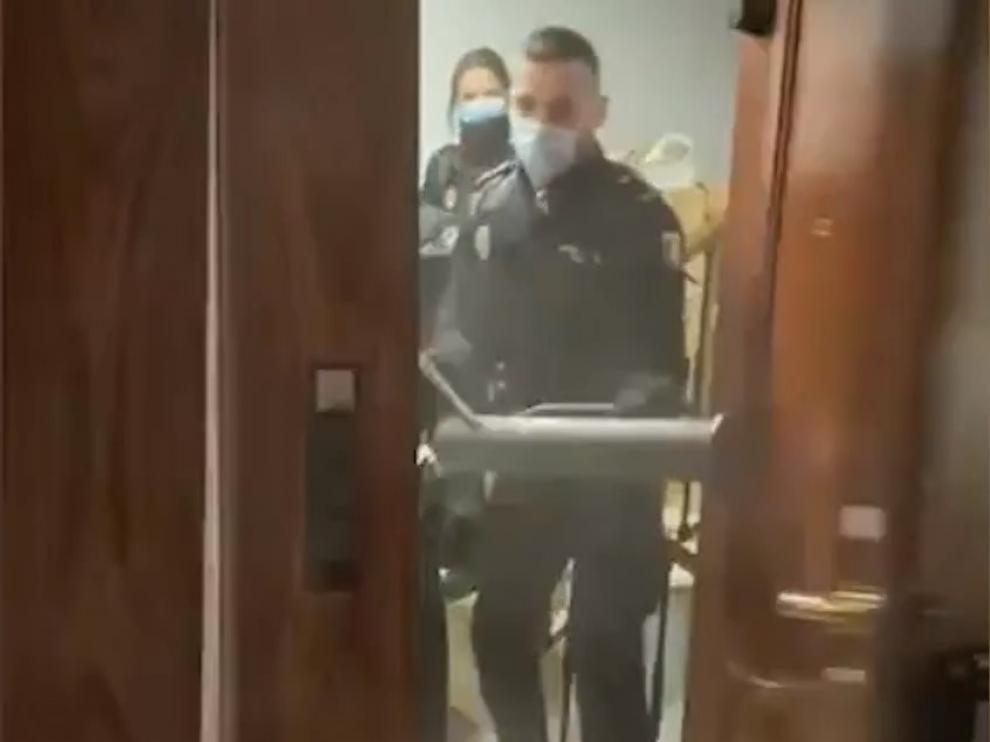 Varios agentes entran, ariete en mano, en un piso donde se celebraba una fiesta.