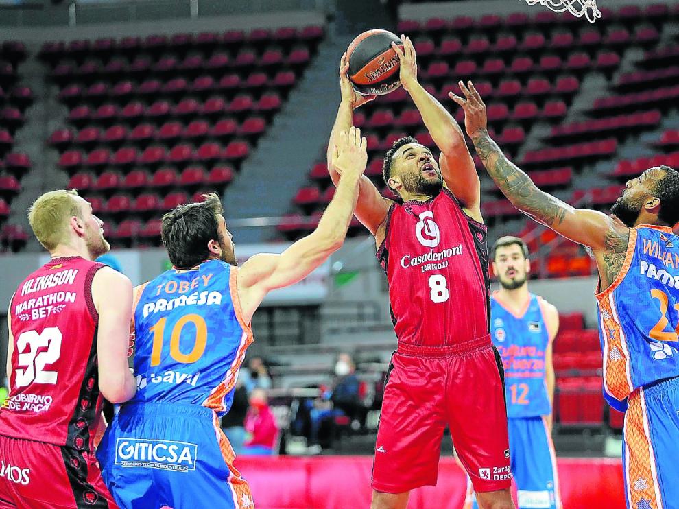 Elias Harris trata de levantar un balón ante la defensa del Valencia Basket, en el último partido de ACB
