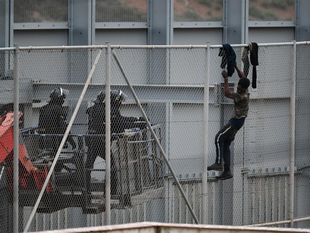Un inmigrante intenta saltar la valla fronteriza de Ceuta, este martes.
