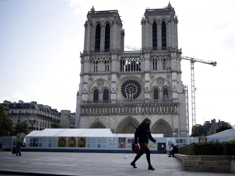 Una mujer pasa por delante de Notre Dame, la víspera de que se cumplan dos años del incendio.