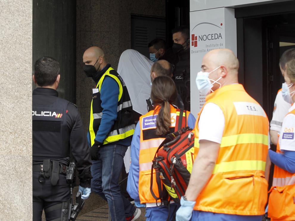 Los agentes policiales se llevan arrestado al presunto autor del suceso (cubierto con una sábana blanca).