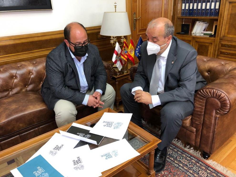 El presidente Rando y del vicepresidente Izquierdo, ante los distintos modelos del logotipo del Día de San Jorge de la DPT.