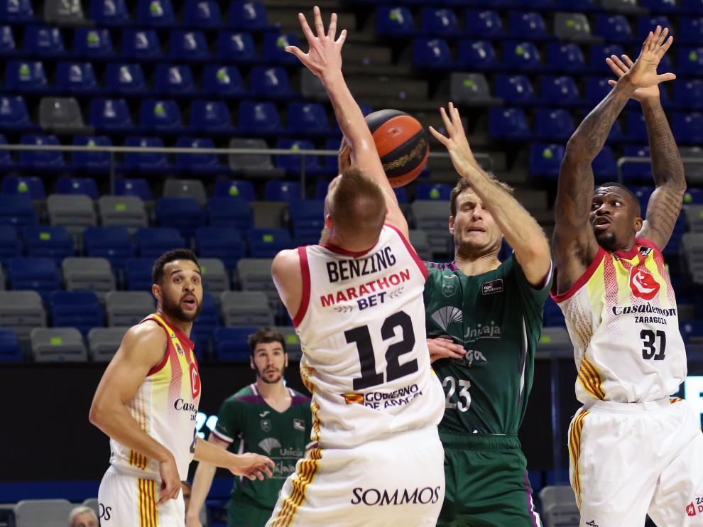 Benzing y Ennis defienden a Tim Abromaitis.