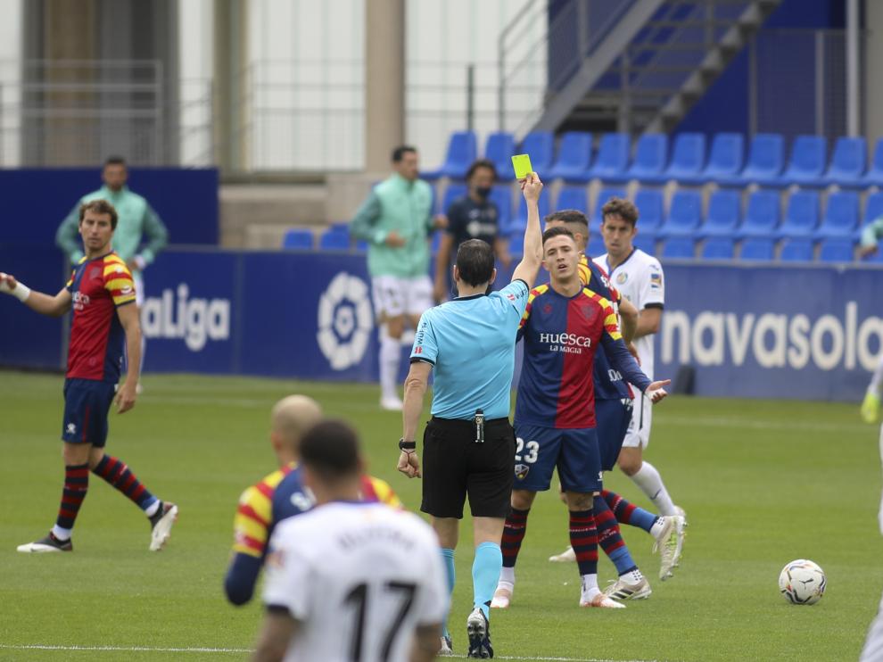 El árbitro Martínez Munuera muestra a Escriche la tarjeta amarilla en el partido con el Getafe.
