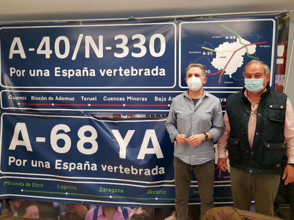 Dos colaboradores de Teruel Existe, Pascual Giménez -izquierda- y Enrique Marín, con las pancartas reivindicativas.