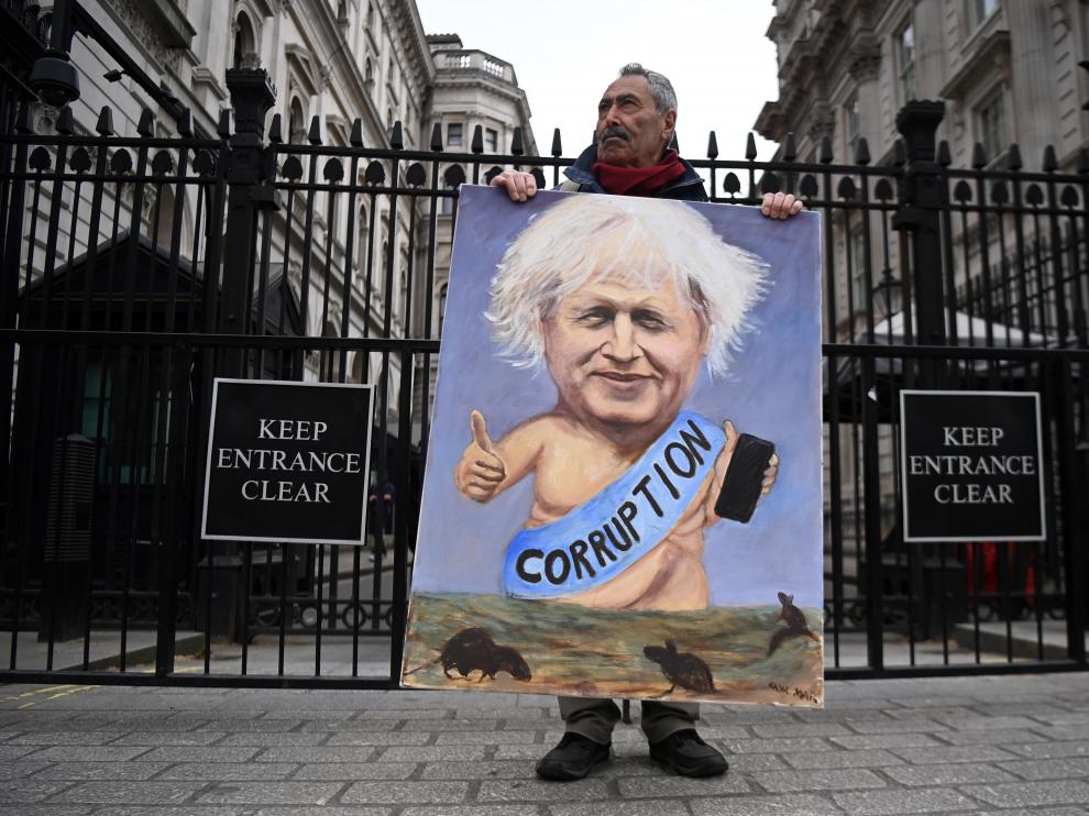 El dibujante satírico Kaya Mar, con una caricatura de Johnson delante de la residencia oficial del primer ministro