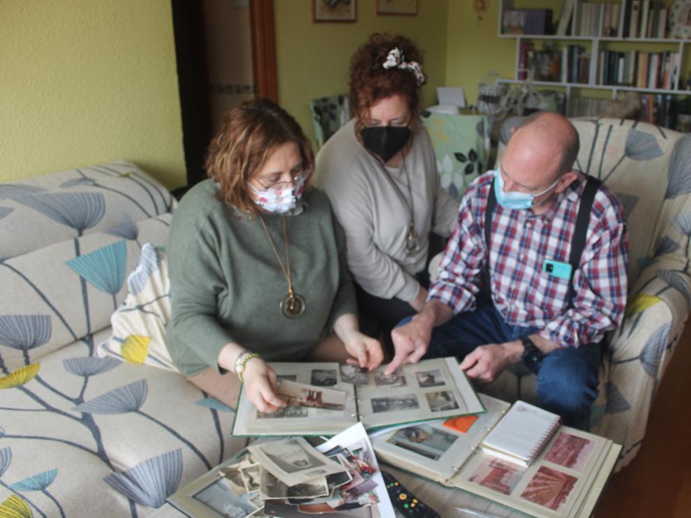 María Ángeles, Beatriz y Carlos hojean el álbum familiar, lleno de recuerdos de su madre, que murió durante el confinamiento, en abril de hace un año.