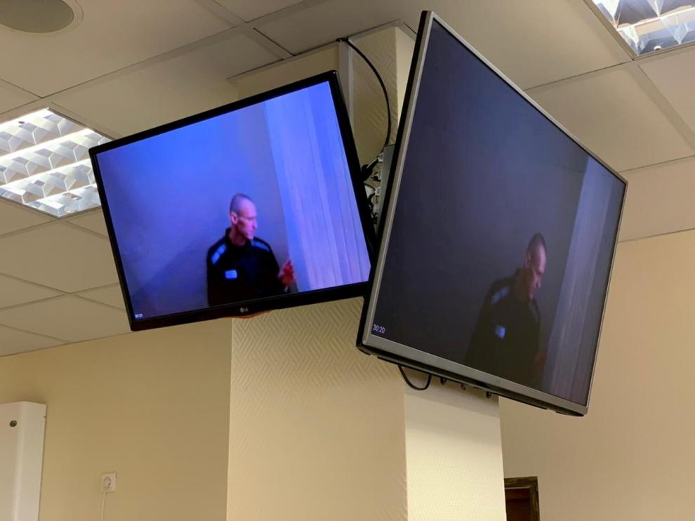Navalni, en dos monitores de televisión durante su nueva vista judicial.