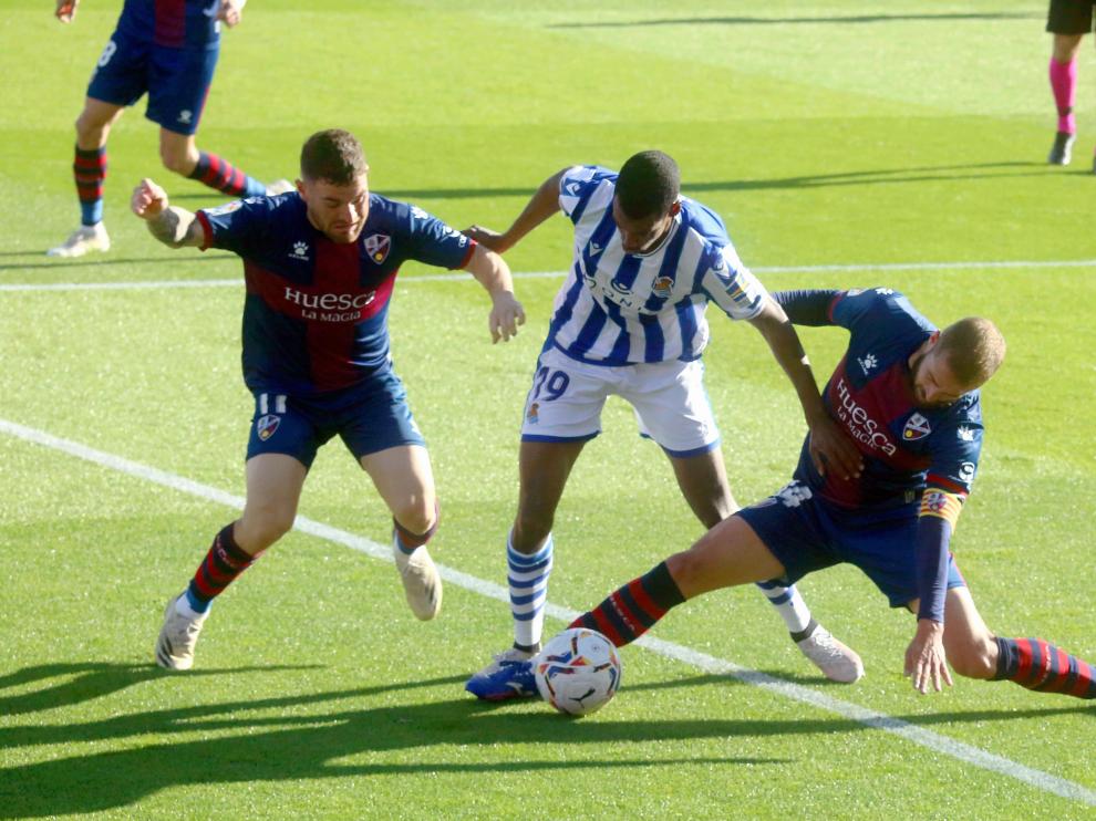 Pulido trata de cortar con Galán el avance de Isak durante el choque entre la SD Huesca y la Real Sociedad.