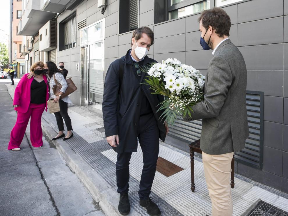 Borja Giménez, con un ramo de flores, y su hermano Manuel, ante la palca que recuerda el asesinato de su padre en la calle Cortes de Aragón el 6 de mayo de 2001.