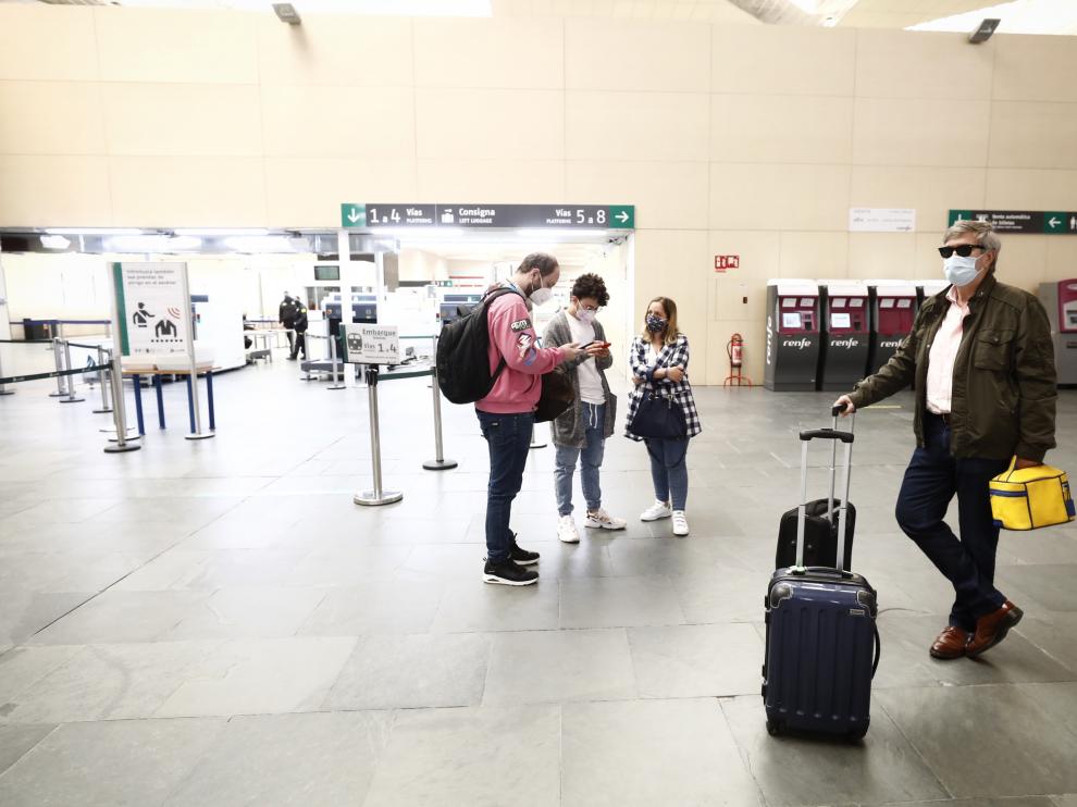 Viajeros esperan en la estación de Delicias de Zaragoza la llegada del tren Ouigo que llega con retraso.