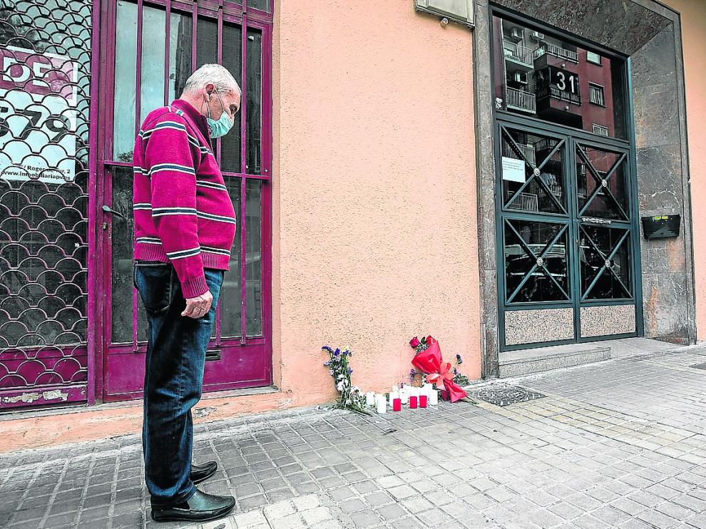 Un vecino del bloque, emocionado, observa las flores y velas depositadas en recuerdo de Katia.